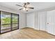 Bright bedroom featuring light wood floors, neutral walls, a ceiling fan, and sliding glass doors to the balcony at 404 72Nd Ave. N # 206, Myrtle Beach, SC 29572