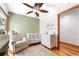 Bright Bedroom with a white crib, dresser, ceiling fan, and hardwood floors at 4240 Highway 17 Business, Murrells Inlet, SC 29576