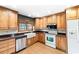 Well-lit kitchen with light wood cabinets, stainless steel appliances, a farmhouse sink, and tiled floors at 4240 Highway 17 Business, Murrells Inlet, SC 29576