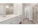 Bright bathroom with double sink vanity, quartz countertops, framed mirrors and a glass door shower at 5019 Riverton Ct, Myrtle Beach, SC 29579