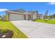 This exterior view showcases a spacious driveway and attractive landscaping, under a clear, blue sky at 5019 Riverton Ct, Myrtle Beach, SC 29579