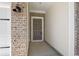Close-up view of the home's front entrance, featuring brick accents and a modern light fixture at 5019 Riverton Ct, Myrtle Beach, SC 29579