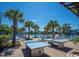 Outdoor recreational area featuring ping pong tables, surrounded by palm trees and lounge seating, for entertainment at 524 Farrow Pkwy., Myrtle Beach, SC 29577