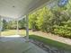 A covered patio offers shade and a view of a backyard, creating an inviting place to relax and enjoy nature at 5333 Abbey Park Loop, Myrtle Beach, SC 29579