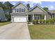 Charming two-story home with a well-manicured lawn, a two-car garage, and classic architectural details at 5333 Abbey Park Loop, Myrtle Beach, SC 29579