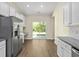 Bright kitchen features stainless steel appliances, white cabinets, and sliding glass door to the outside at 5333 Abbey Park Loop, Myrtle Beach, SC 29579