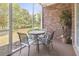 Cozy screened porch with seating area surrounded by lush landscaping and a brick wall at 5801 Oyster Catcher Dr. # 912, North Myrtle Beach, SC 29582