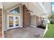 Inviting covered patio featuring a brick fireplace and double French doors, perfect for outdoor living at 584 Circle Dr., Surfside Beach, SC 29575
