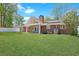 Expansive backyard showcasing lush green lawn, a brick house exterior, and solar panels at 584 Circle Dr., Surfside Beach, SC 29575