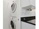 Convenient laundry space with stacked washer/dryer and modern white cabinetry at 584 Circle Dr., Surfside Beach, SC 29575