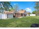 Well-maintained yard with green grass, a brick house, and a detached garage or shed at 584 Circle Dr., Surfside Beach, SC 29575