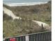 Scenic path leads to the beach, framed by natural vegetation and a peek of the ocean at 6000 Ocean Blvd. N # 108, North Myrtle Beach, SC 29582