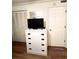 Bright bedroom with a white dresser and TV, with ample storage provided by closet at 6000 Ocean Blvd. N # 108, North Myrtle Beach, SC 29582