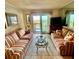 Relaxing living room with striped couches, glass table, fireplace and balcony access at 6000 Ocean Blvd. N # 108, North Myrtle Beach, SC 29582