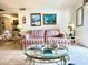 Comfortable living room with striped sofa, and glass tables, perfect for relaxation and style at 6000 Ocean Blvd. N # 108, North Myrtle Beach, SC 29582