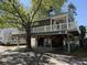 Elevated home featuring a white picket fence porch, ground level parking, and a fun bar and entertainment area at 6001-8050 S Kings Hwy., Myrtle Beach, SC 29575