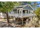 Charming raised beach house featuring a spacious porch, elevated structure, and lush landscaping at 6001-8050 S Kings Hwy., Myrtle Beach, SC 29575