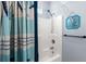 Bright shower area with a blue-themed shower curtain and decorative wall art at 6001-8050 S Kings Hwy., Myrtle Beach, SC 29575