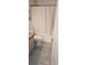 Bathroom features wood cabinets, modern fixtures, toilet, shower with white curtain and gray wood-look tile floors at 6001-Z55 South Kings Hwy., Myrtle Beach, SC 29575