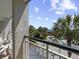 Balcony view showcasing lush landscaping, palm trees, and a glimpse of the ocean at 601 Retreat Beach Circle # 215, Pawleys Island, SC 29585