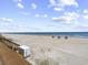 Picturesque beach scene with soft sand, clear ocean, and scattered beach umbrellas at 601 Retreat Beach Circle # 215, Pawleys Island, SC 29585