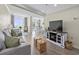 Comfortable living room with large windows, hardwood floors, and a modern TV console offers a relaxing atmosphere at 601 Retreat Beach Circle # 215, Pawleys Island, SC 29585