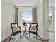 Inviting sitting area featuring two wicker chairs and large windows with view of the pool at 601 Retreat Beach Circle # 215, Pawleys Island, SC 29585