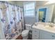 Neat bathroom with a charming shower curtain, toilet, vanity, and view into living room, perfect for everyday use at 93 Weatherboard Ct., Pawleys Island, SC 29585