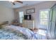 Bright bedroom with a walk-out balcony, dresser with mounted TV, and a ceiling fan, for comfort and convenience at 93 Weatherboard Ct., Pawleys Island, SC 29585