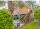Elevated home showcasing covered parking, wooden stairs, and tropical landscaping at 93 Weatherboard Ct., Pawleys Island, SC 29585