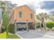 Inviting raised beach home with a well manicured lawn and outdoor entertaining area at 93 Weatherboard Ct., Pawleys Island, SC 29585