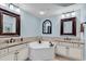 Bright bathroom featuring double vanities, a soaking tub, and stylish mirrors at 9547 Edgerton Dr. # 702, Myrtle Beach, SC 29572