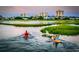 Scenic view of two people kayaking on a tranquil river surrounded by waterfront homes at 9547 Edgerton Dr. # 702, Myrtle Beach, SC 29572