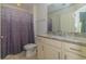 Well-lit bathroom with a vanity, granite countertop, and shower with purple curtain at 105 Villa Mar Dr. # C-1, Myrtle Beach, SC 29579