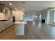 Open-concept kitchen flowing into the living room, featuring a large island, fireplace, and wood-look floors at 1059 Laconic Dr., Myrtle Beach, SC 29588