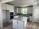 Modern kitchen with white cabinets, stainless steel appliances, and a center island at 1237 Lady Bird Way, North Myrtle Beach, SC 29582
