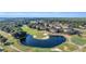 Aerial view of a golf course community with manicured greens, a pond, and elegant residential buildings at 1313 Villa Marbella Ct. # 4-102, Myrtle Beach, SC 29572