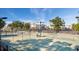 Wide shot of well-maintained community tennis courts, surrounded by mature trees and residential buildings under a clear sky at 1313 Villa Marbella Ct. # 4-102, Myrtle Beach, SC 29572