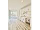 Bright kitchenette with white cabinets, marble countertops, and sliding glass doors leading to the deck at 133 Serenity Point Dr., Little River, SC 29566