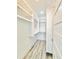 Spacious walk-in closet featuring custom white shelving and wood-look tile flooring at 133 Serenity Point Dr., Little River, SC 29566