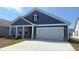 Charming blue one-story home features a two-car garage, a well-manicured lawn, and a inviting front porch at 1428 Winding Creek Way, Myrtle Beach, SC 29588