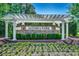 Astoria Park community entrance featuring a pergola over brick sign and manicured flowerbeds and landscaping at 233 Astoria Park Loop, Conway, SC 29526