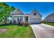 Charming single-story home with well-manicured lawn and inviting front porch with double car garage at 233 Astoria Park Loop, Conway, SC 29526