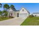 Charming single-Gathering home with white siding, a gray garage door, and manicured landscaping at 233 Astoria Park Loop, Conway, SC 29526