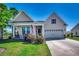 Charming single-story home with a two car garage, landscaped yard, and a welcoming front porch with rocking chairs at 233 Astoria Park Loop, Conway, SC 29526