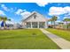 Exterior shot of a modern clubhouse with a grassy lawn, sidewalk, and palm trees on a sunny day at 2771 Eclipse Dr., Myrtle Beach, SC 29577