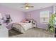 Bright bedroom with lilac walls, a ceiling fan, and a cozy bed with stuffed animals at 3110 Bramble Glen Dr., Myrtle Beach, SC 29579