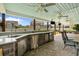 View of the covered outdoor kitchen area with sink, grill, mini-fridge, and bar seating at 3110 Bramble Glen Dr., Myrtle Beach, SC 29579