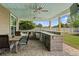 Covered outdoor kitchen featuring built-in grill, bar, and outdoor dining area at 3110 Bramble Glen Dr., Myrtle Beach, SC 29579