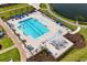 Aerial view of community pool with blue umbrellas, lounge chairs, and manicured landscaping at 3110 Bramble Glen Dr., Myrtle Beach, SC 29579